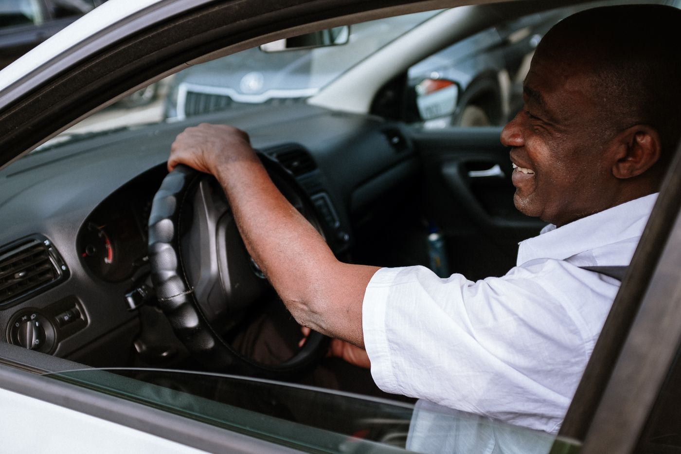 Homme souriant au volant d’une voiture